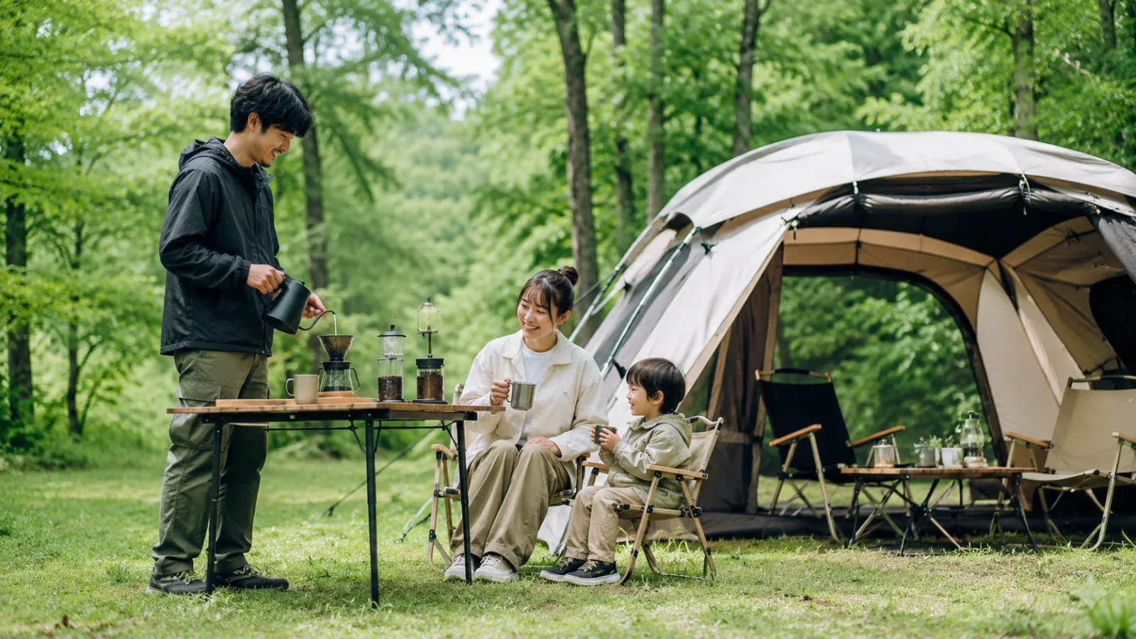 森のキャンプ場で家族がハンドドリップコーヒーを楽しむ様子
