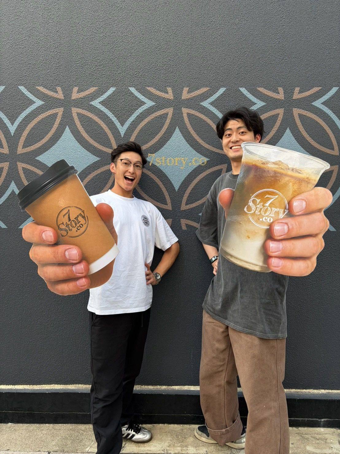 ホットとアイスのカップを掲げる二人のスタッフ
